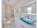 Bright bathroom featuring a unique blue glass bowl sink, a large mirror, and a glass-enclosed shower at 13004 Boca Ciega Ave, Madeira Beach, FL 33708