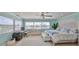 Serene bedroom with large windows offering water views, light wood floors and detailed headboard at 13004 Boca Ciega Ave, Madeira Beach, FL 33708