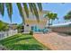 Inviting two-story home with a bright blue door, brick driveway, and lush lawn at 13004 Boca Ciega Ave, Madeira Beach, FL 33708