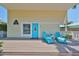 Inviting front porch with comfortable seating and a bright blue door at 13004 Boca Ciega Ave, Madeira Beach, FL 33708
