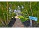 Charming home entrance with a brick walkway leading through lush palm trees, enhanced by a decorative mailbox at 13004 Boca Ciega Ave, Madeira Beach, FL 33708