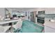 Modern kitchen with stainless steel appliances, bright white cabinets, and an adjacent dining area at 13004 Boca Ciega Ave, Madeira Beach, FL 33708