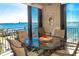 Relaxing balcony setting with table and chairs overlooking a stunning bay view and Gulf Blvd Signage at 1380 Gulf Blvd # 1008, Clearwater Beach, FL 33767