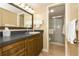 Well-lit bathroom featuring wooden cabinetry, a sink, and a walk-in shower at 1380 Gulf Blvd # 1008, Clearwater Beach, FL 33767