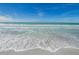Scenic view of waves gently rolling onto a pristine, sun-kissed beach under a bright blue sky at 1380 Gulf Blvd # 1008, Clearwater Beach, FL 33767
