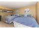 Neutral-toned bedroom featuring two beds with striped linens, overhead storage, and nautical decor at 1380 Gulf Blvd # 1008, Clearwater Beach, FL 33767