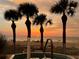 Hot tub on balcony with palm trees and sunset over the ocean at 1380 Gulf Blvd # 1008, Clearwater Beach, FL 33767