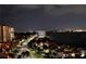 Night view of the illuminated street, waterfront condos, bay, and city skyline across the water at 1380 Gulf Blvd # 1008, Clearwater Beach, FL 33767