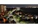 Illuminated street view at night featuring palm trees and nearby residential buildings with bay in background at 1380 Gulf Blvd # 1008, Clearwater Beach, FL 33767