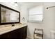 Bathroom with a granite vanity, dark wood cabinets, and a large mirror at 2499 Indigo Dr, Clearwater, FL 33763