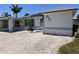Charming single-story home with a paver driveway and landscaped yard at 14845 N Bayshore Dr, Madeira Beach, FL 33708