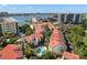 Aerial view of community featuring tile roofs, lush landscaping, and a swimming pool at 240 Windward Psge # 602, Clearwater Beach, FL 33767