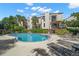 Relaxing pool area with inviting lounge chairs, lush landscaping, and multiple balconies on units above at 240 Windward Psge # 602, Clearwater Beach, FL 33767