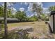 Spacious backyard featuring a grassy area, a wood fence, and mature trees on a sunny day at 7414 Van Dyke Rd, Odessa, FL 33556