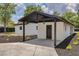 Cozy carport with a concrete slab, black posts and trim, and a stylish hanging light fixture at 7414 Van Dyke Rd, Odessa, FL 33556
