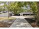 Long driveway leading to a house with a two-car garage surrounded by mature trees at 7414 Van Dyke Rd, Odessa, FL 33556