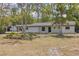 Charming single-story home featuring a fresh white exterior, dark roof, and well-maintained landscaping at 7414 Van Dyke Rd, Odessa, FL 33556