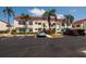 Front view of the condo building with parking area and lush landscaping at 6011 Bahia Del Mar Blvd # 150, St Petersburg, FL 33715