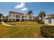 Exterior view of a two-story condo building with balconies, lush landscaping, and palm trees at 6011 Bahia Del Mar Blvd # 150, St Petersburg, FL 33715