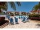 Community pool area with several blue lounge chairs and lush landscaping at 6011 Bahia Del Mar Blvd # 150, St Petersburg, FL 33715