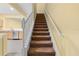 Carpeted staircase with white railing, view of kitchen at 2619 Redford Way, Wesley Chapel, FL 33544