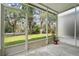 Screened patio overlooks a grassy backyard with mature trees at 2619 Redford Way, Wesley Chapel, FL 33544