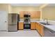 Modern kitchen features stainless steel appliances and light wood cabinets at 2619 Redford Way, Wesley Chapel, FL 33544