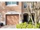 Townhouse exterior with a double garage and manicured landscaping at 2619 Redford Way, Wesley Chapel, FL 33544