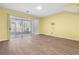 Bright living room with wood-look floors and sliding glass doors to patio at 2619 Redford Way, Wesley Chapel, FL 33544
