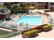 Bright community pool area with lounge chairs, surrounded by lush landscaping and multi-story buildings at 1 Key Capri # 104E, Treasure Island, FL 33706