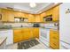 Bright kitchen with light wood cabinets, tile backsplash, and essential appliances at 1 Key Capri # 104E, Treasure Island, FL 33706
