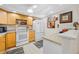 Bright kitchen featuring wood cabinets, white appliances, and tile flooring at 1 Key Capri # 104E, Treasure Island, FL 33706