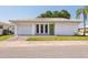 White single story home with attached garage and green door at 5396 Acacia N Trl, Pinellas Park, FL 33782