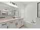 Bathroom with double vanity, large mirror, and soaking tub at 31275 Spruceberry Ct, Wesley Chapel, FL 33543
