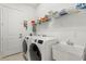 Convenient laundry room with washer, dryer, and utility sink at 31275 Spruceberry Ct, Wesley Chapel, FL 33543