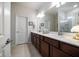 Double vanity bathroom with a large mirror and a shower at 20591 Monza Loop, Land O Lakes, FL 34638