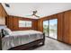 Main bedroom with wood paneled walls and sliding glass doors at 1811 Martin Rd, Dover, FL 33527