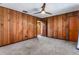 Bright bedroom featuring wood paneled walls and ceiling fan at 1811 Martin Rd, Dover, FL 33527