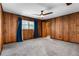 Cozy bedroom with wood walls, window, and ceiling fan at 1811 Martin Rd, Dover, FL 33527