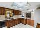 Kitchen boasts wood cabinets, a double sink, and views into the Gathering room at 1811 Martin Rd, Dover, FL 33527