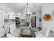 Charming dining area with a glass table, white chairs, and a unique chandelier at 5523 Carlton Rd, New Port Richey, FL 34652