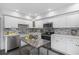 Updated kitchen featuring white cabinets, stainless steel appliances, and tile backsplash at 5523 Carlton Rd, New Port Richey, FL 34652