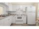 White kitchen with granite countertops and stainless steel appliances at 4239 Tamargo Dr, New Port Richey, FL 34652