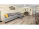 Living room with gray sofas, hardwood floors, and views to the dining area at 4239 Tamargo Dr, New Port Richey, FL 34652