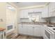 White kitchen cabinets, granite countertops, and a pass-through to the dining area at 4239 Tamargo Dr, New Port Richey, FL 34652