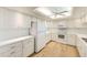Well-equipped kitchen with white cabinets and light wood floors at 736 Island Way # 404, Clearwater Beach, FL 33767