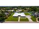 Aerial shot of a home with metal roof, a wide green lawn, and a long paved driveway at 3931 38Th S Way, St Petersburg, FL 33711