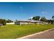 Charming single-story home with metal roof, a green lawn, and well maintained landscaping at 3931 38Th S Way, St Petersburg, FL 33711