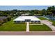 Aerial view of a home with metal roof, lush lawn, and long driveway in a desirable neighborhood at 3931 38Th S Way, St Petersburg, FL 33711