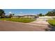 Gray house with metal roof, landscaping, and driveway at 3931 38Th S Way, St Petersburg, FL 33711